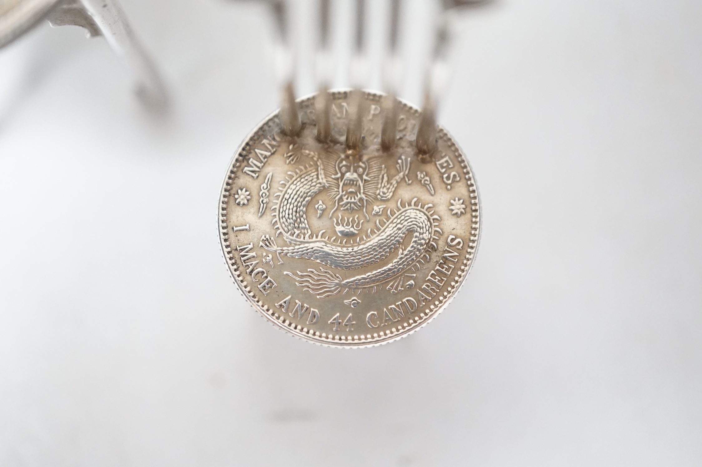 A Chinese Republic period one dollar 1920, and two Chinese Guangxu period coins mounted as miniature furniture, table 4vm higher